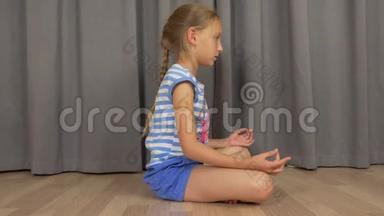 年轻女孩坐在禅坐在客厅的地板上打坐。 女孩练习瑜伽。